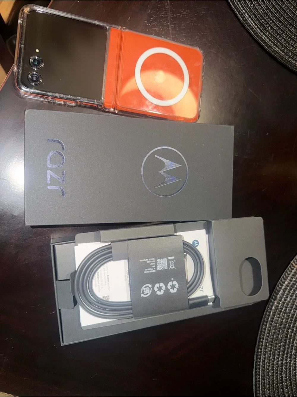 Motorola black smartphone with clear case and orange accents